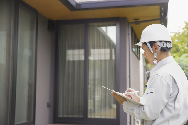 戸建ての外観をチェックしている作業員
