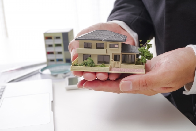 家の模型を持つ男性