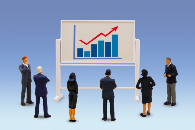 右肩上がりのグラフを見るビジネスマンたち