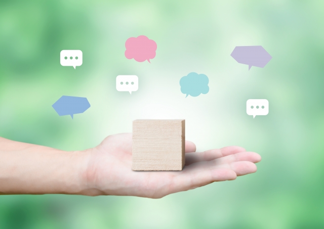 口コミと積み木を持つ手