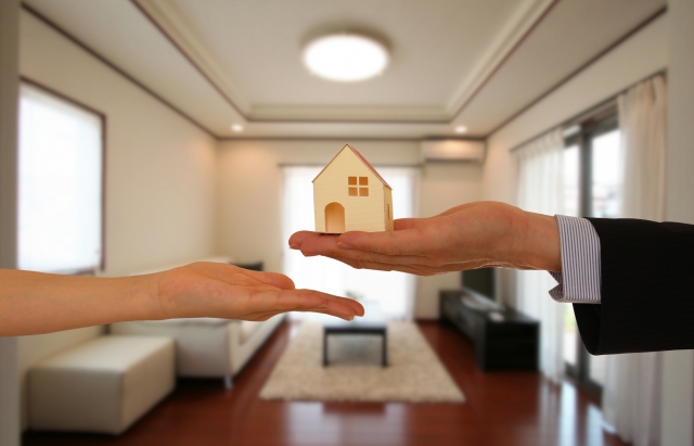 リビングで家の模型をもつ手